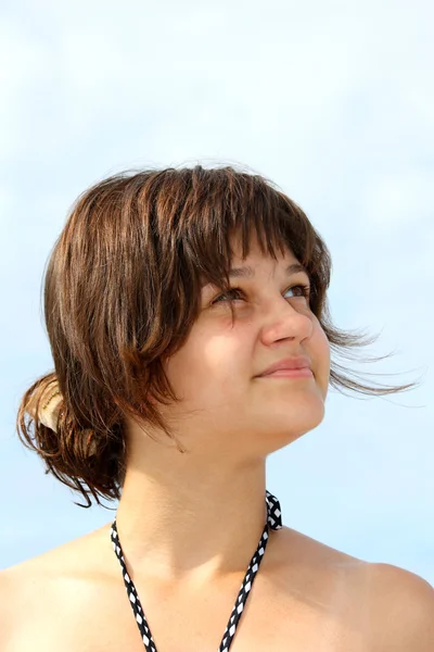 Mladá dívka na pláži vypadá na obloze — Stock fotografie