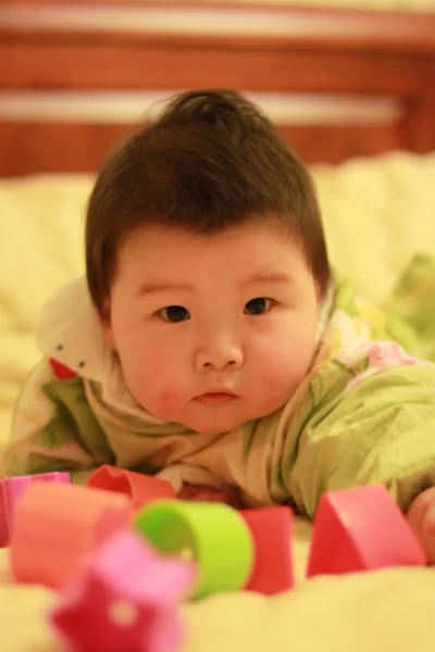 Baby spielt Spielzeug im Bett — Stockfoto