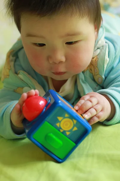 Bebê brincando brinquedos na cama — Fotografia de Stock