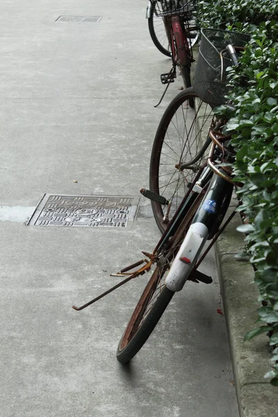 Стареющий велосипед припаркован на улице — стоковое фото