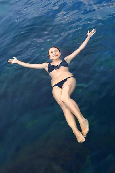 Jong meisje liggend op het water — Stockfoto