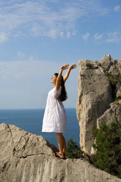Glad ung flicka stående på klipporna — Stockfoto