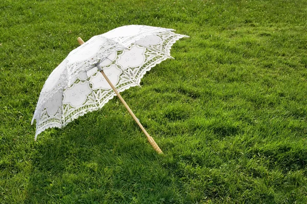 Άσπρο κομψό ομπρέλα στο φρέσκο χορτάρι — Φωτογραφία Αρχείου