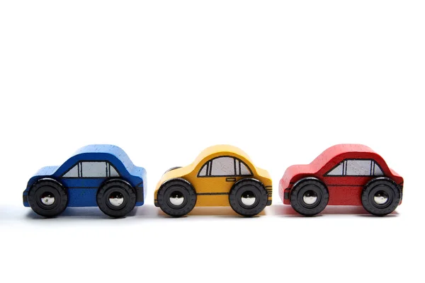 Três carros de brinquedo de madeira em uma linha — Fotografia de Stock
