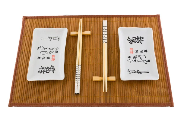 stock image Two sets of dishes for sushi on the mat