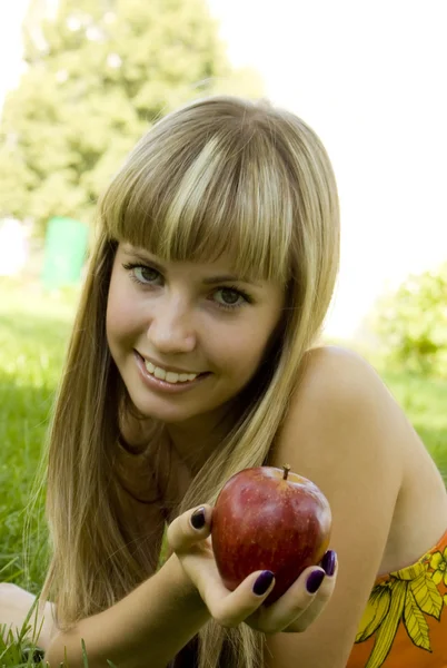 Девушка с красным яблоком на улице — стоковое фото