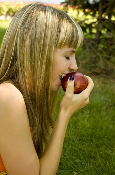 Девушка с красным яблоком на улице — стоковое фото