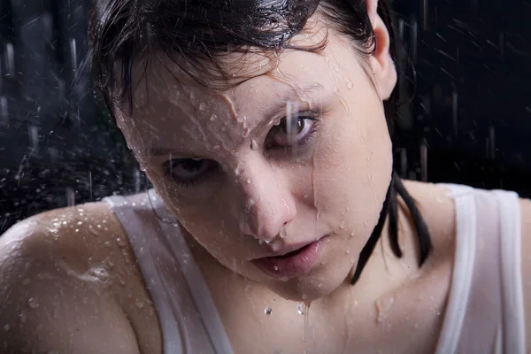Giovane ragazza adulta guardando attraverso la goccia di pioggia — Foto Stock