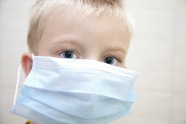 Lapsi, jolla on lääketieteellinen naamio ja savusumu — kuvapankkivalokuva