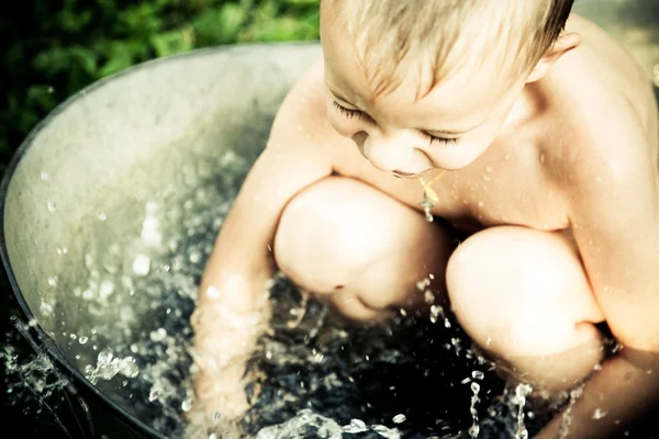 Liten pojke lek med vatten — Stockfoto