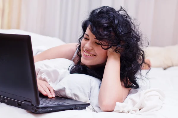Πορτραίτο γυναίκας, βάζοντας στο κρεβάτι με το lap-top — Φωτογραφία Αρχείου