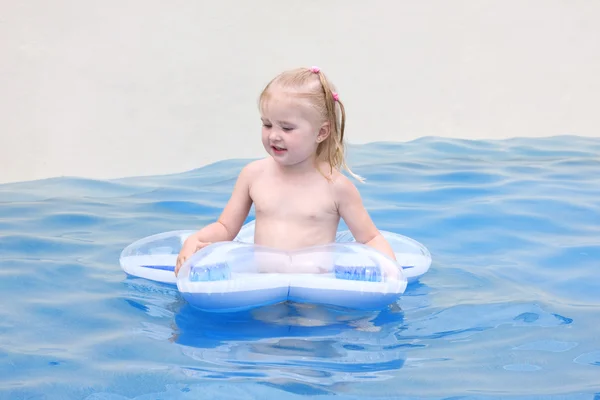 Happy small girl in a pool — Stock Photo, Image