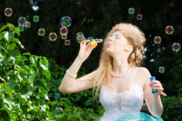 Krásná nevěsta fouká mýdlové bubliny — Stock fotografie