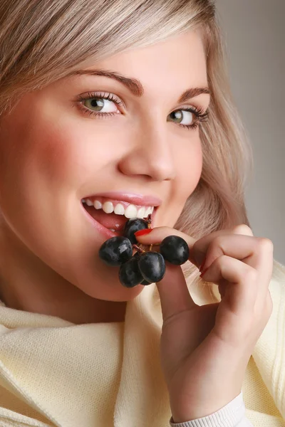 Jovem mulher atraente comendo uva — Fotografia de Stock