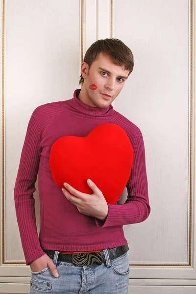 Jovem homem atraente segurando um coração vermelho — Fotografia de Stock