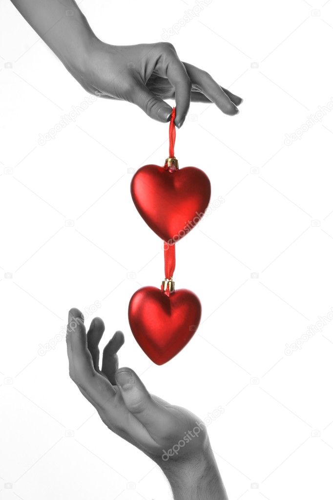 Two hands holding red hearts