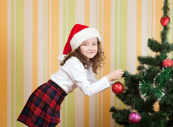 Menina com bola para árvore de natal — Fotografia de Stock