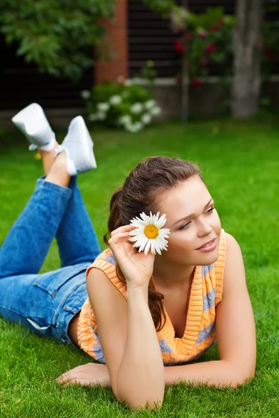 Ragazza con fiore sull'erba — Foto Stock
