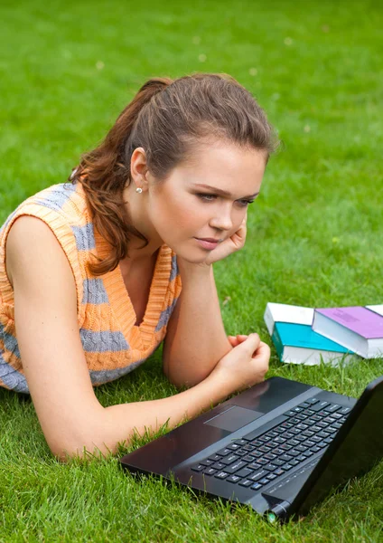 草上有笔记本电脑的女孩 — 图库照片