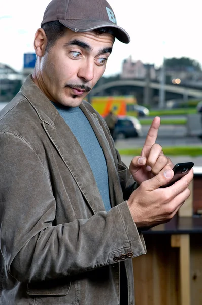Смішний портрет чоловіка з мобільним телефоном на відкритому повітрі — стокове фото