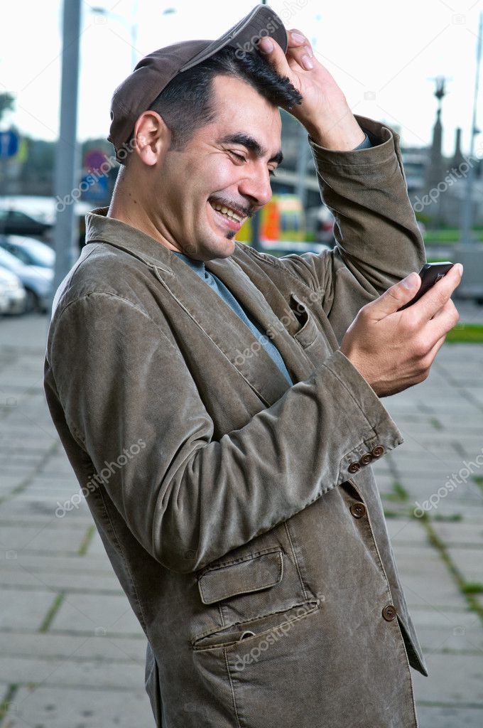 Happy man with mobile phone outdoors