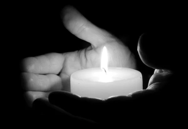 Человеческие руки держат свечу — стоковое фото