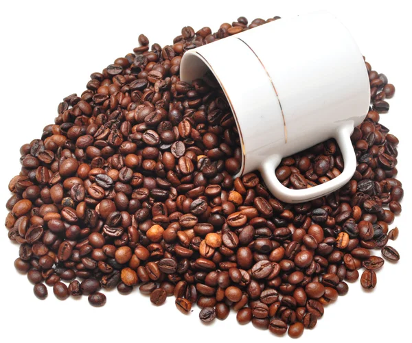 Кофейные зерна падают с чашки кофе — стоковое фото
