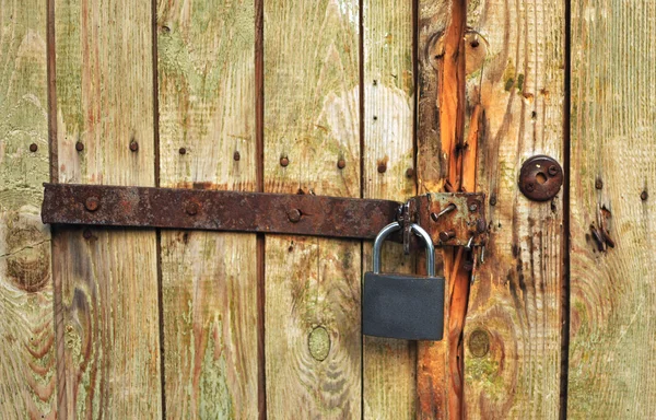 Železného šroubu na dřevěné dveře se zámkem — Stock fotografie