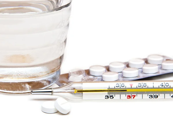 Close up glass with water and some pill and thermometer — Stock Photo, Image
