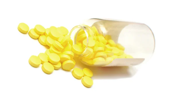 Garrafa de vidro com comprimidos amarelos — Fotografia de Stock
