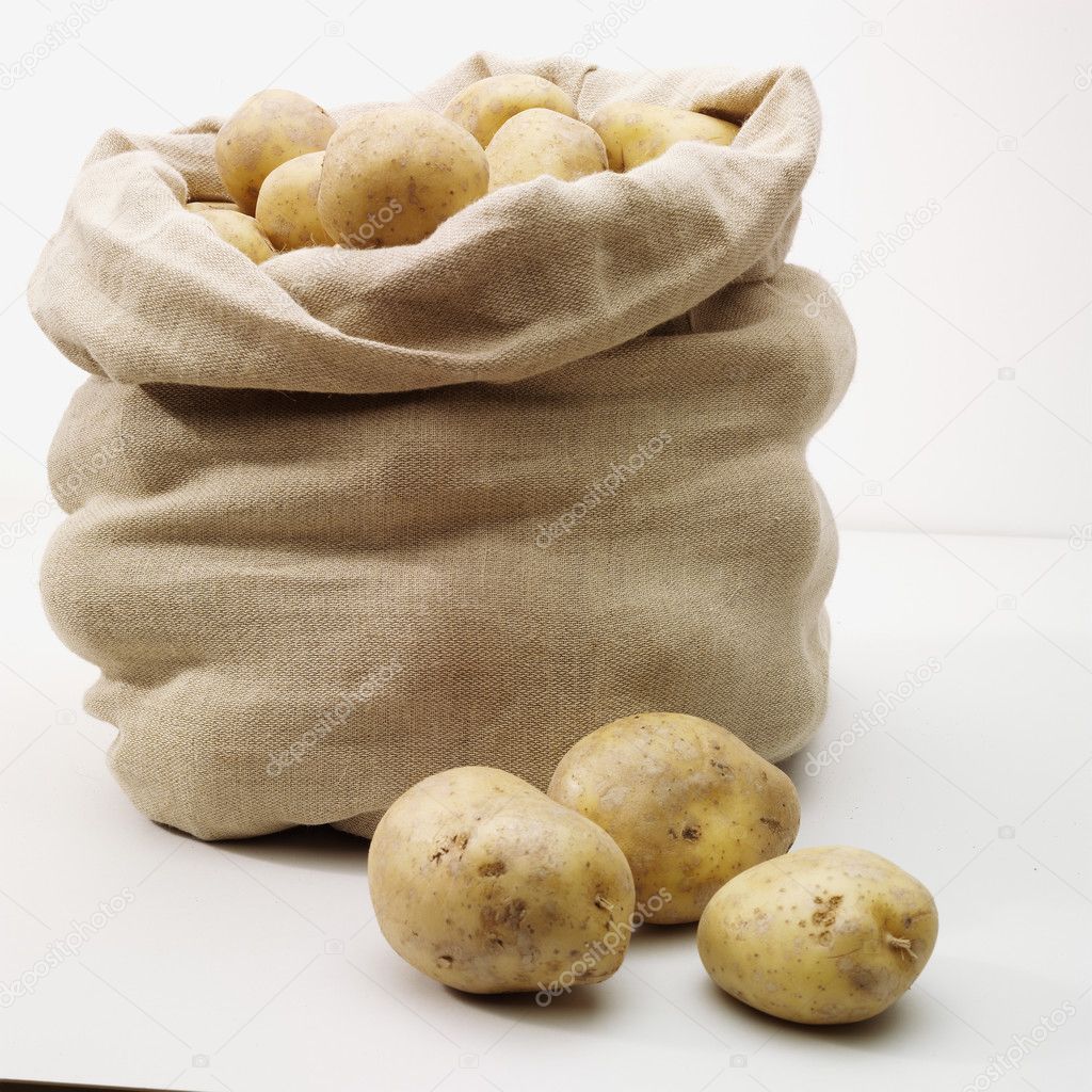 Overflowing bag of potatoes on whit