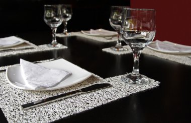 Glass, fork and knife on the restaurant table clipart