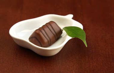 Piece of chocolate and green leaf clipart