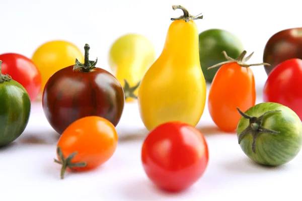 Colorful tomatoes on white fabric — Stock Photo, Image