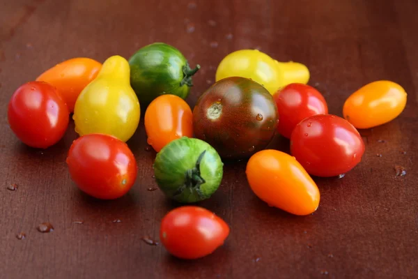 Świeże pomidory mokre na drewnianym stole — Zdjęcie stockowe