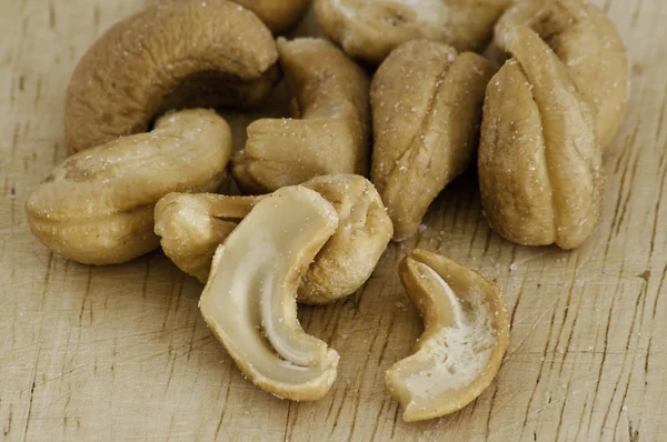 stock image Heap of a roasted cashew nuts on an old wooden table.