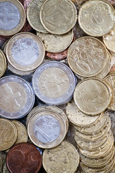 Shiny euro coins frozen in ice — Stock Photo, Image