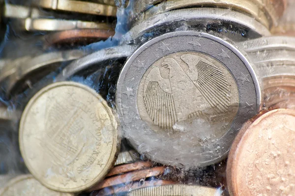 Shiny euro coins frozen in ice with german coin in front — Stock Photo, Image
