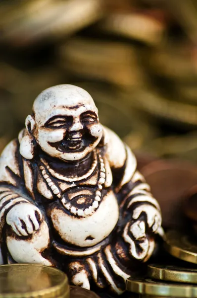 stock image Laughing Budda in front of coins