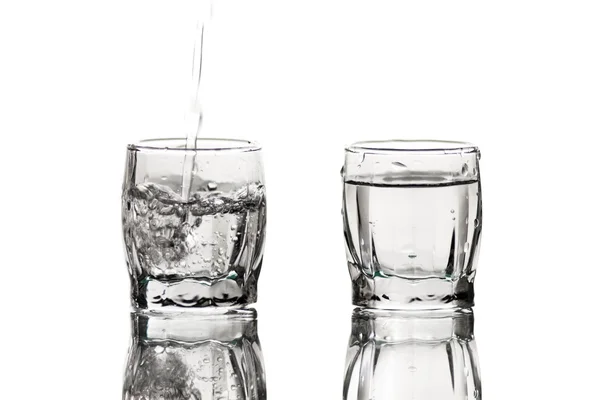 Spruzzare acqua versando in un bicchiere — Foto Stock