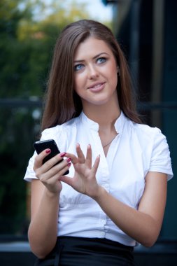 genç kadın gülümsüyor elinde telefon ile