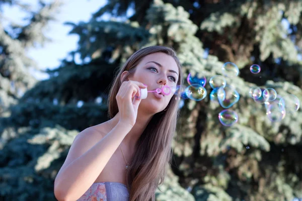 Young woman makes soap bubbles — Stock Photo, Image