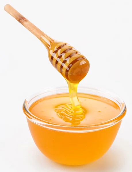 Miel que vierte de palo al tazón — Foto de Stock