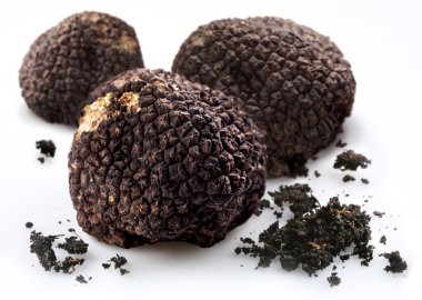 Black truffles with the pieces of soil on a white background clipart