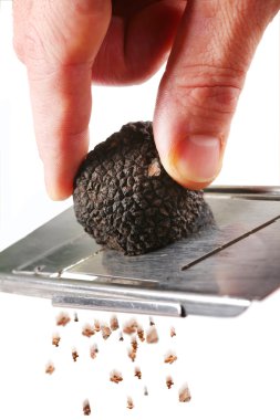 The mushroom of truffle is ground on a grater on a white background clipart