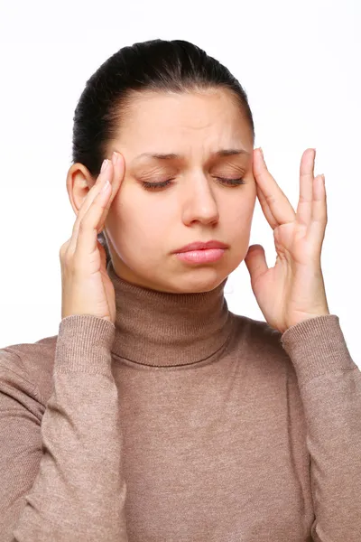 Грустная молодая женщина страдает головной болью и массирует виски пальцами — стоковое фото