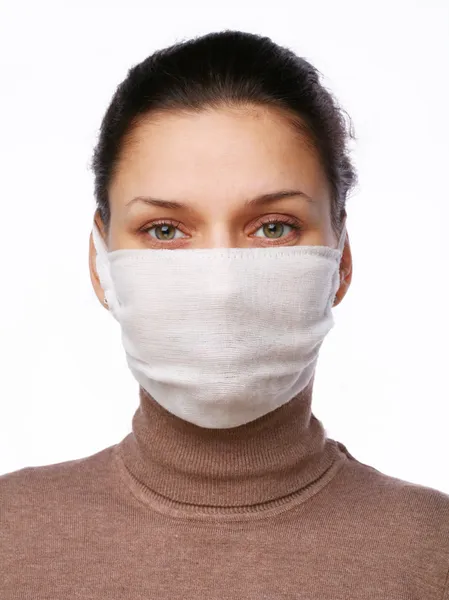 Junge Frau in medizinischer Maske auf weißem Hintergrund — Stockfoto