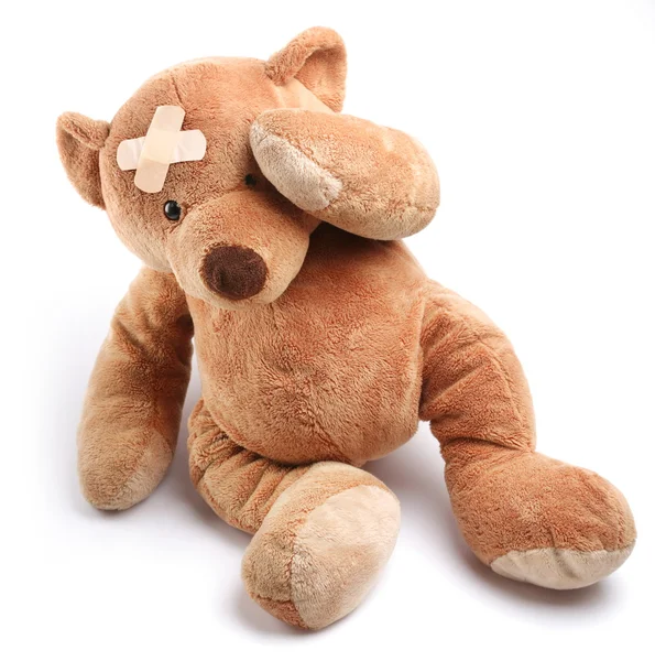 Ziek teddybeer met gips op zijn kop — Stockfoto