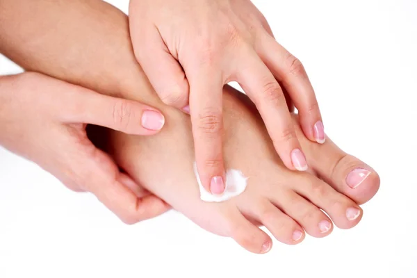 Giovane donna si preoccupa per i suoi piedi, applicando crema su di loro . — Foto Stock