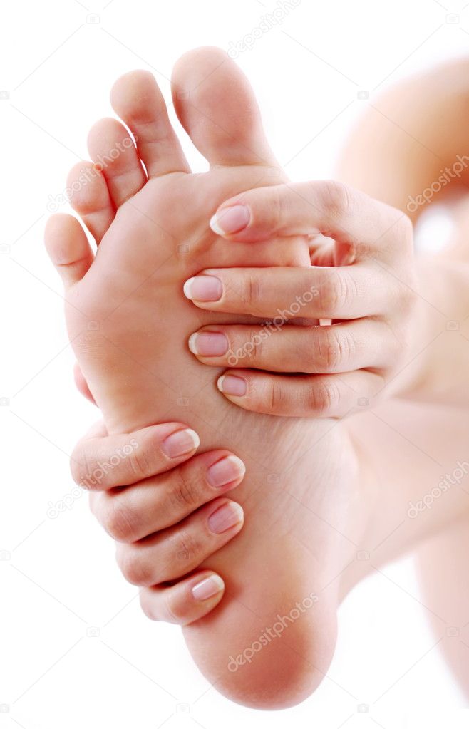Young woman massages her foot. On a white background.